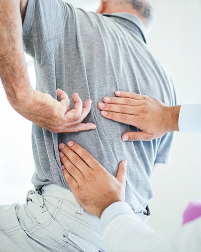 Person With Back Pain Pointing To Their Back