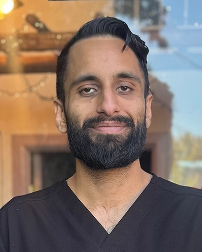 Chiropractor Tukwila WA Sukhmeet Mand HP Sukhmeet Mand smiling while wearing a black shirt.